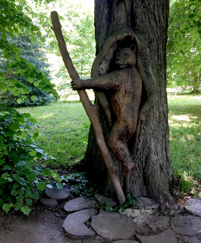 Деревянные фигуры - медведь в стволе дерева